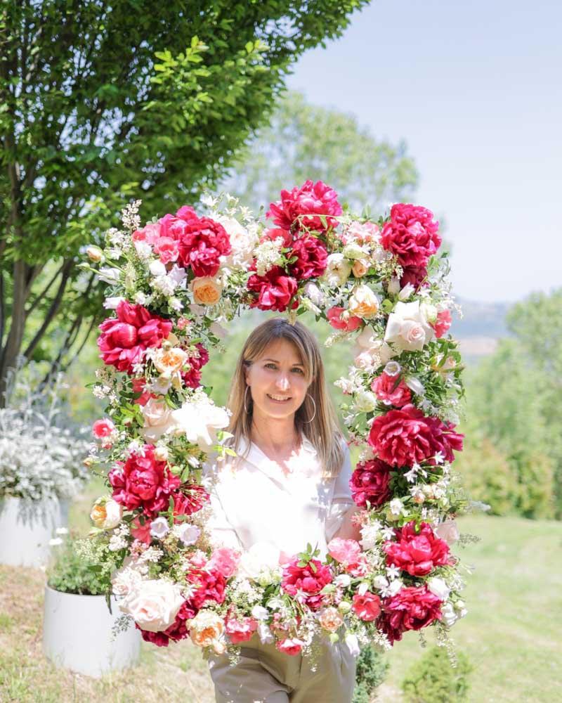 la fiorista che presenta la cornice floreale per il flower booth